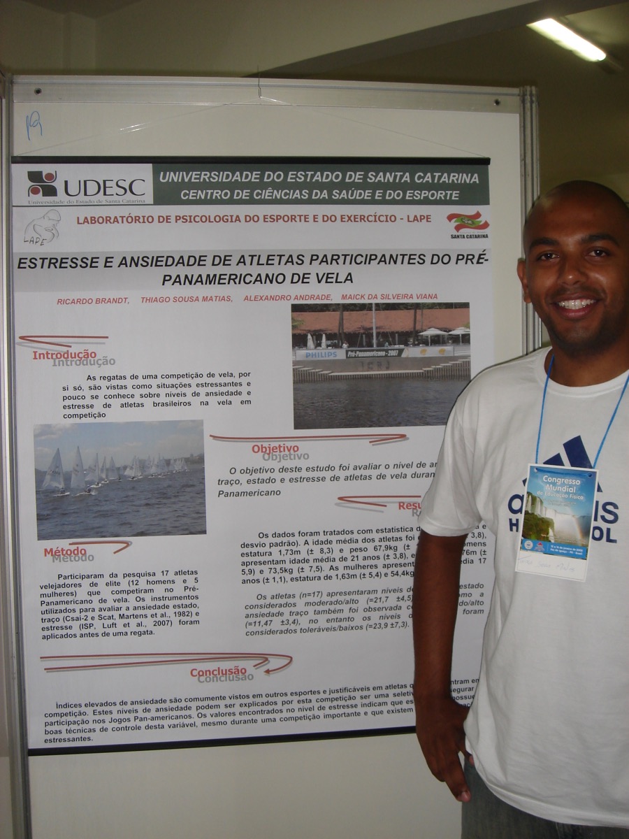 Thiago Matias jovem ao lado de pôster científico no Congresso Mundial de Educação Física, Foz do Iguaçu